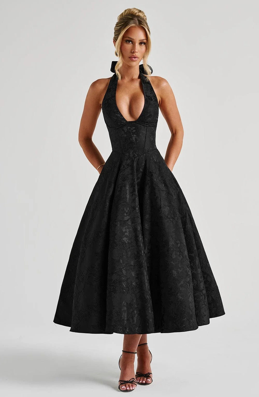 Vestido de corte evasé con detalle floral en la cintura.
