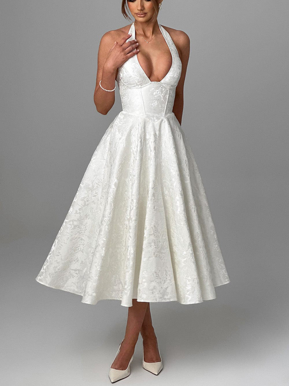 Vestido de corte evasé con detalle floral en la cintura.
